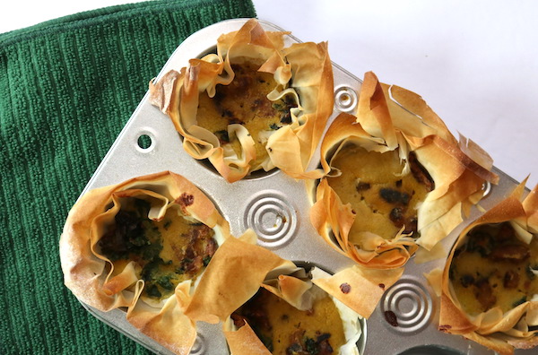 a muffin tin filled with individual mini quiches 